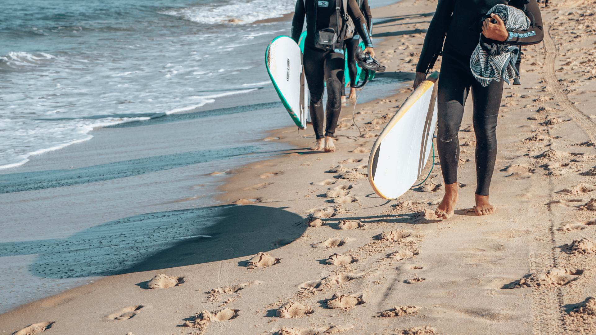 two-surfers-carrying-surfboards-on-gold-coast-beach